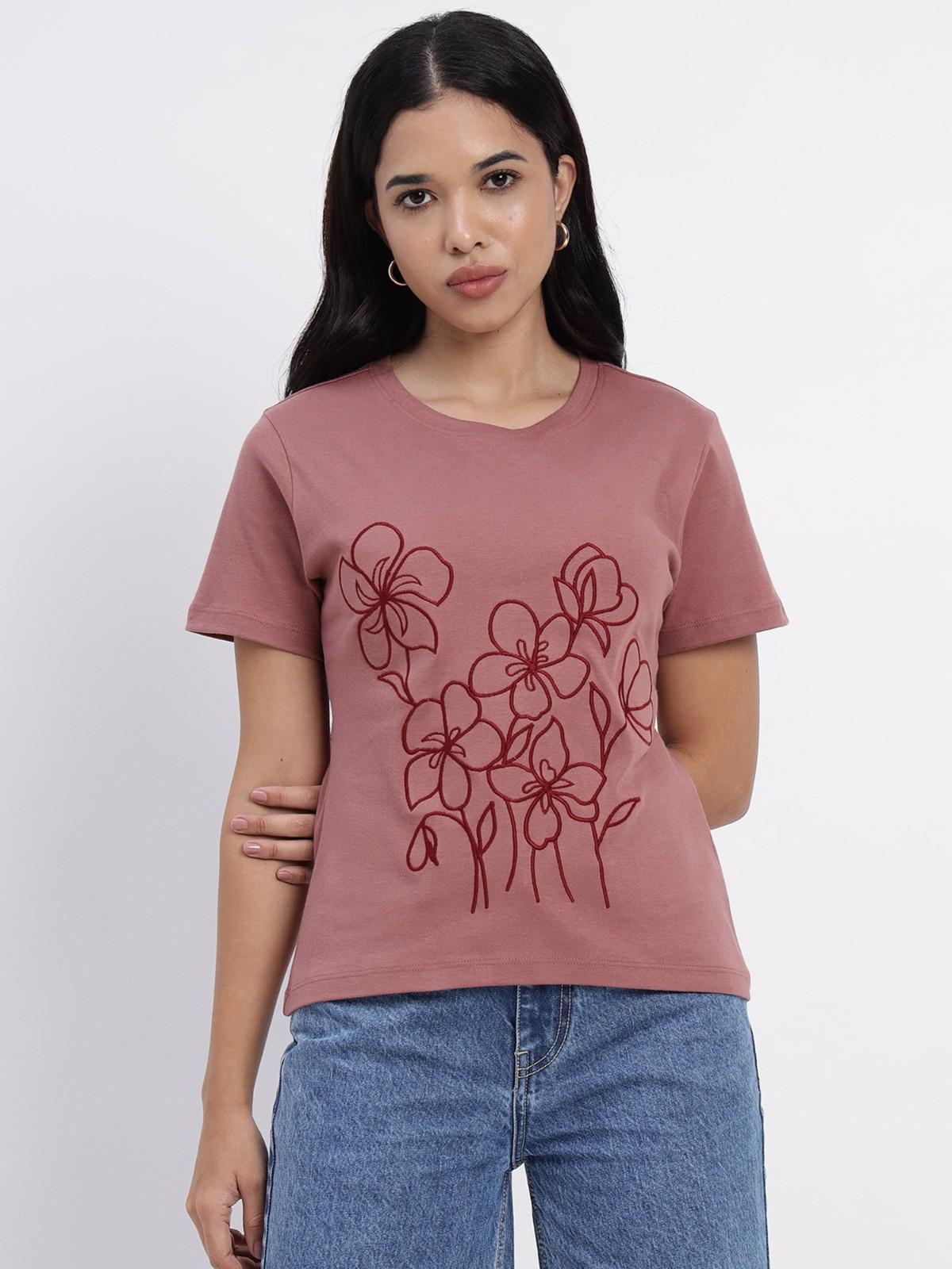 Salmon colored t shirt featuring white floral prints